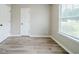 Sun-filled bedroom showcasing wood-look floors and a large window at 228 Roberts Trl, Locust Grove, GA 30248