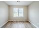 Bright bedroom features wood-look floors, neutral paint, and a window at 228 Roberts Trl, Locust Grove, GA 30248