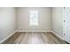 A bright bedroom has wood-look floors and a window at 228 Roberts Trl, Locust Grove, GA 30248