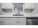 Close-up of a modern sink, dishwasher, and countertop framed by white cabinets at 228 Roberts Trl, Locust Grove, GA 30248