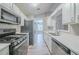 Well-lit kitchen with stainless steel appliances, white cabinets, and stone countertops at 228 Roberts Trl, Locust Grove, GA 30248