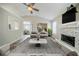 Airy, virtually staged living room with white fireplace and open layout to the dining area at 228 Roberts Trl, Locust Grove, GA 30248