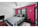 Bedroom with a bed, ceiling fan, and bright accent wall at 76 Riverbend Trl, Douglasville, GA 30134