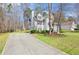 View of the two-story home's side with a long driveway, showcasing the home's setting and landscaping at 76 Riverbend Trl, Douglasville, GA 30134