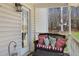 Cozy covered front porch with comfortable wicker furniture and decorative pillows, perfect for relaxing outdoors at 76 Riverbend Trl, Douglasville, GA 30134