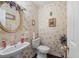 Charming powder room with decorative wallpaper, a pedestal sink, and elegant fixtures at 76 Riverbend Trl, Douglasville, GA 30134