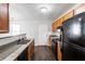 Updated kitchen with granite counters, wood cabinets, and black appliances at 900 Oakhill Sw Ave, Atlanta, GA 30310