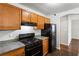 Functional kitchen featuring wood cabinets, granite countertops, and black appliances at 900 Oakhill Sw Ave, Atlanta, GA 30310