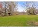 Expansive backyard with green lawn, mature trees, and two gazebos overlooking the serene lake at 106 Maple St, Roswell, GA 30075