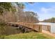 Charming wooden bridge stretching across calm lake waters, surrounded by lush greenery at 106 Maple St, Roswell, GA 30075
