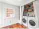 Functional laundry room with a washer, dryer, storage shelves, and a window, offering convenience and practicality at 106 Maple St, Roswell, GA 30075