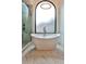 Bright bathroom with a modern white tub, marble floors, a glass-enclosed shower, and a large arched window at 237 Webney Se Dr, Marietta, GA 30068