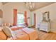 Charming bedroom with chandelier, hardwood floors, and two white iron frame beds at 237 Webney Se Dr, Marietta, GA 30068
