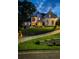 Twilight shot of a two-story white brick home with beautifully lit landscaping, highlighting its architectural details at 237 Webney Se Dr, Marietta, GA 30068
