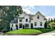Elegant, two-story white brick home with manicured lawn and mature trees, exuding curb appeal and classic charm at 237 Webney Se Dr, Marietta, GA 30068