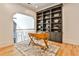 Office space featuring a built-in bookshelf, wood floors, a modern rug, and a unique desk with a metal frame at 237 Webney Se Dr, Marietta, GA 30068