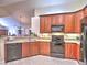 Well-lit kitchen with stainless steel appliances, tiled floor, and natural wood cabinets at 2730 Vintage Reserve Ln, Marietta, GA 30066