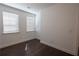 An empty bedroom with white walls and dark wood flooring features natural light and windows at 6569 Beacon Dr, Sandy Springs, GA 30328
