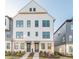 Charming three-story townhome featuring a white facade, brick accents, and a well-maintained lawn at 6569 Beacon Dr, Sandy Springs, GA 30328
