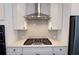 Modern kitchen showcasing a gas cooktop with stylish stainless steel range hood and white cabinetry at 6569 Beacon Dr, Sandy Springs, GA 30328