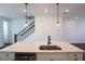 Bright kitchen island features a stainless steel sink, faucet, dishwasher and elegant pendant lighting at 6569 Beacon Dr, Sandy Springs, GA 30328