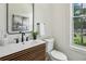 Well-lit powder room featuring modern sink, wood vanity, decorative mirror, and natural light at 1792 Charles Nw Pl, Atlanta, GA 30318