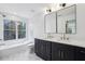 Modern bathroom featuring double sinks, black cabinets, white countertops, and subway tile at 1792 Charles Nw Pl, Atlanta, GA 30318