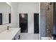 Modern bathroom showcasing a sleek vanity, contrasting black doors, and tiled shower with a rainfall showerhead at 1792 Charles Nw Pl, Atlanta, GA 30318