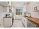 Well-lit kitchen featuring white cabinets, butcher block countertops, and stainless steel appliances at 1792 Charles Nw Pl, Atlanta, GA 30318