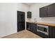 Modern kitchenette features dark cabinetry, stainless steel appliances, and butcher block countertops at 1792 Charles Nw Pl, Atlanta, GA 30318