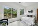 Serene main bedroom with a white textured headboard, a private balcony with green views and modern décor at 1792 Charles Nw Pl, Atlanta, GA 30318