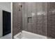 Close up of shower featuring a white bathtub and sleek tile work with a recessed shelf for storage at 1792 Charles Nw Pl, Atlanta, GA 30318
