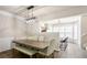 Light-filled dining area featuring a wooden table with upholstered chairs and a modern pendant light fixture at 223 Riverstone Commons Cir, Canton, GA 30114