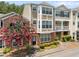 Inviting townhouse showcasing a beautifully landscaped front and multi-level facade with a flowering tree at 223 Riverstone Commons Cir, Canton, GA 30114