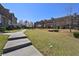 Exterior showcases manicured community green space with sidewalks connecting brick townhomes on a sunny day at 3022 Hartford Mill, Duluth, GA 30097