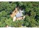Aerial view showing a gray roofed house surrounded by dense, tall trees and a circular driveway at 4720 Timberland Sw Dr, Mableton, GA 30126