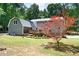 Backyard with a deck, gray vinyl siding, a red maple tree, and green grass at 4720 Timberland Sw Dr, Mableton, GA 30126