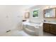 Bathroom featuring a soaking tub, vanity, storage cabinets, and a window at 4720 Timberland Sw Dr, Mableton, GA 30126