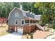 View of a gray two-story house with a red brick foundation, attached garage, and a white porch at 4720 Timberland Sw Dr, Mableton, GA 30126