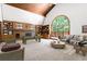 Spacious living room with a soaring ceiling, hardwood bookshelves and a large arched window to the backyard at 4720 Timberland Sw Dr, Mableton, GA 30126