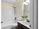Bathroom with white subway tile, tub, shower, dark vanity and bronze fixtures at 522 Bass Nw Pointe, Kennesaw, GA 30144