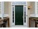 Elegant dark green front door with sidelights and a transom window, framed by white trim and siding at 522 Bass Nw Pointe, Kennesaw, GA 30144