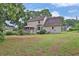A spacious backyard with a well-kept lawn, a covered deck, and mature trees is ideal for outdoor activities at 962 Cove Lake Ct, Lawrenceville, GA 30045