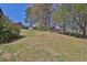 Spacious grassy backyard with mature trees, featuring a charming outbuilding, and garden at 962 Cove Lake Ct, Lawrenceville, GA 30045