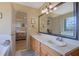 Primary bathroom with double sinks, a large mirror, and a separate room featuring a soaking tub and toilet at 962 Cove Lake Ct, Lawrenceville, GA 30045