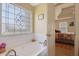 Relaxing bathroom with a large soaking tub and decorative stained glass window at 962 Cove Lake Ct, Lawrenceville, GA 30045