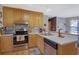 Well-lit kitchen showcasing stainless steel appliances, wood cabinets, and an inviting breakfast nook area at 962 Cove Lake Ct, Lawrenceville, GA 30045