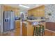 Cozy kitchen with wooden cabinetry, stainless steel refrigerator, and a functional breakfast bar with barstool seating at 962 Cove Lake Ct, Lawrenceville, GA 30045