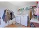 Bright laundry room featuring a washer, dryer, and storage shelf for convenience at 962 Cove Lake Ct, Lawrenceville, GA 30045