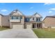 Attractive brick home with a three-car garage, complemented by a green lawn and clear blue skies at 2781 Dolce Rd, Dacula, GA 30019
